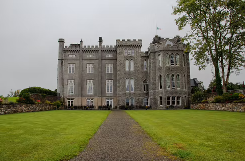 A giant castle with brown walls near woods