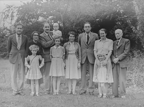  An old image of a large family standing ahead of trees