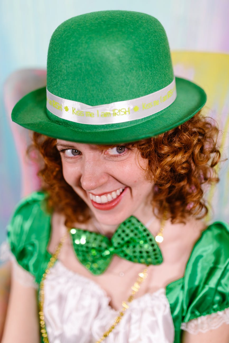 A woman in a green hat is smiling