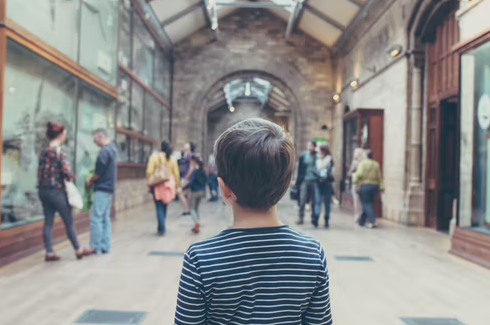 A boy standing as people are enjoying sites of the location