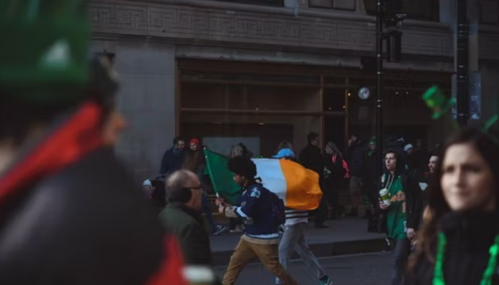 A boy waving Ireland flag in the street
