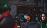 A boy waving Ireland flag in the street