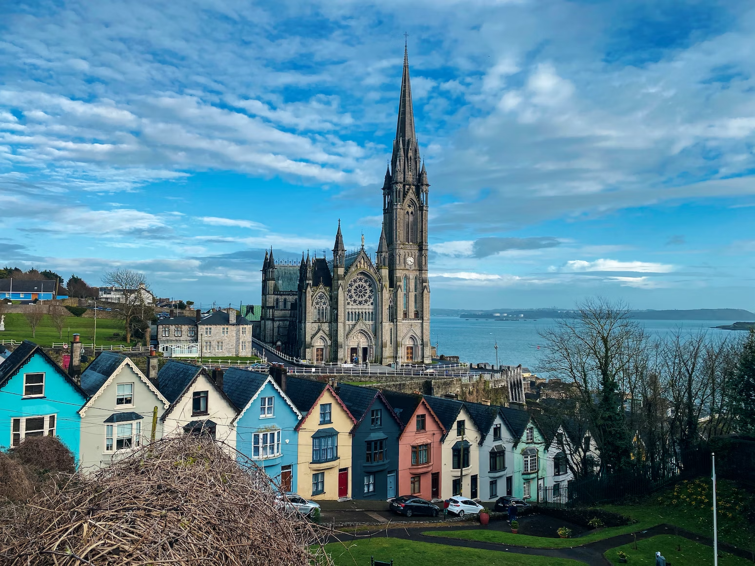 Cork Island, Ireland, featuring a row of colourful houses and a cathedral in the back. 