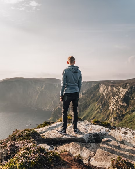 A tourist standing on a hill during a historical tour of Ireland