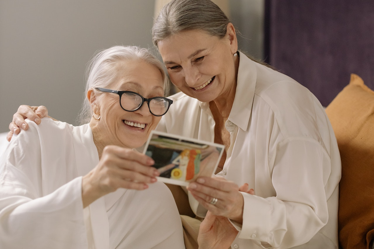 A pair of older women looking at a photo.