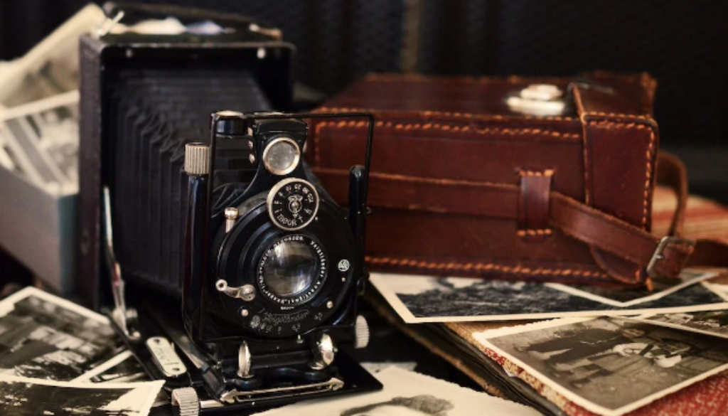 Vintage camera on top of scattered old photos.