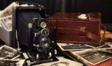 Vintage camera on top of scattered old photos.