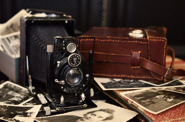 Vintage camera on top of scattered old photos.