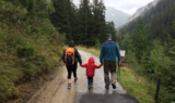 Father walking with children on the road.