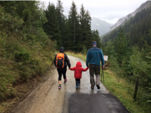 Father walking with children on the road.