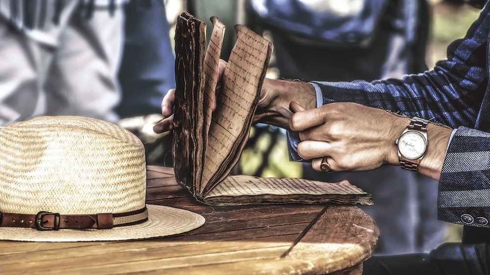 A painting of a man reading old papers