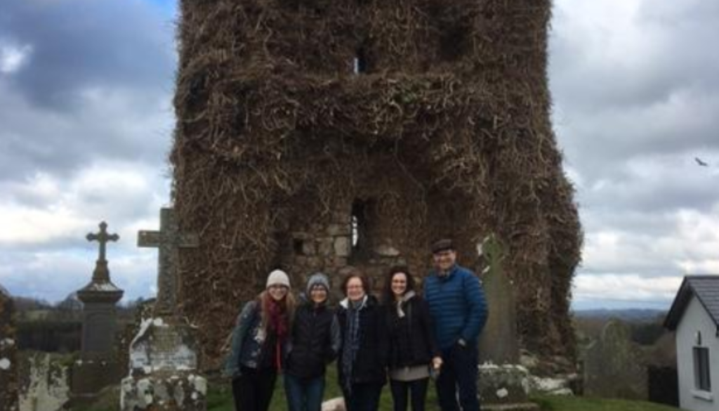 A family visiting their ancestral graveyard during a family history tour.