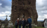 A family visiting their ancestral graveyard during a family history tour.