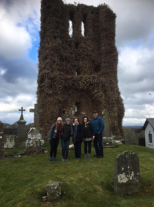 A family visiting their ancestral graveyard during a family history tour.