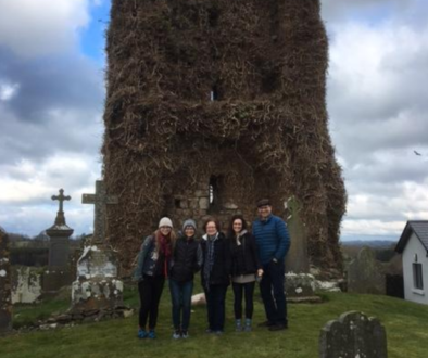 A family visiting their ancestral graveyard during a family history tour.