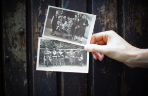 A person holding two old photos.