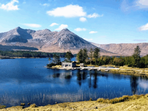 This photo shows a scenic lake surrounded by lush Irish landscape