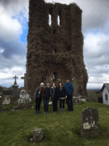 A family visiting a graveyard found through genealogy research in Ireland.