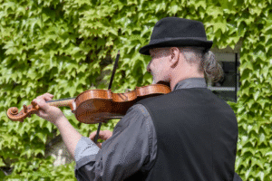 a man playing the violin outdoors.