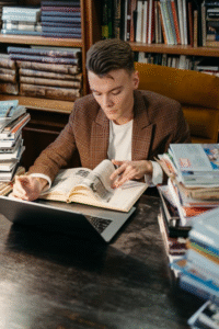 a man at the library in a brown blazer.